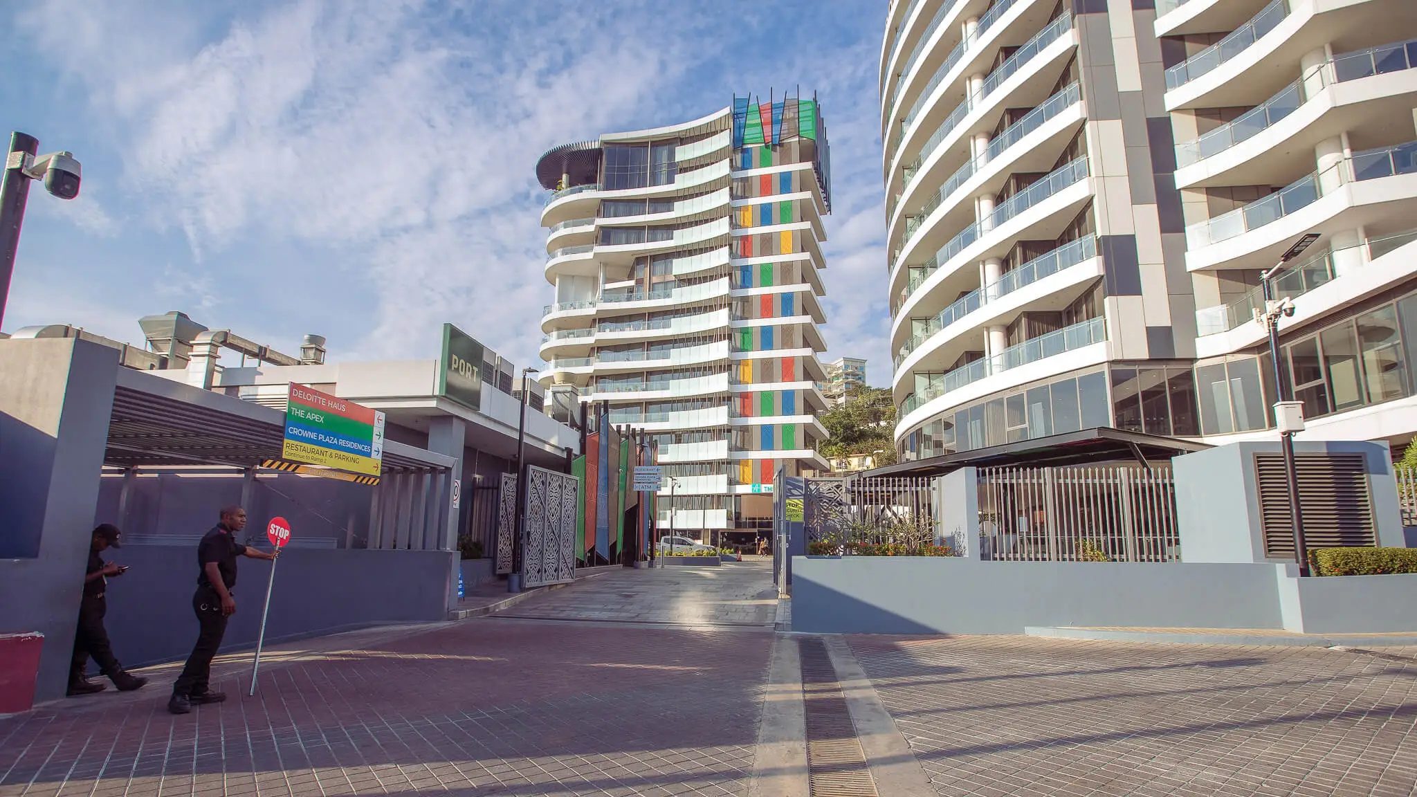 Ground level perspective looking past Nambawan Super Plaza carpark toward The Apex