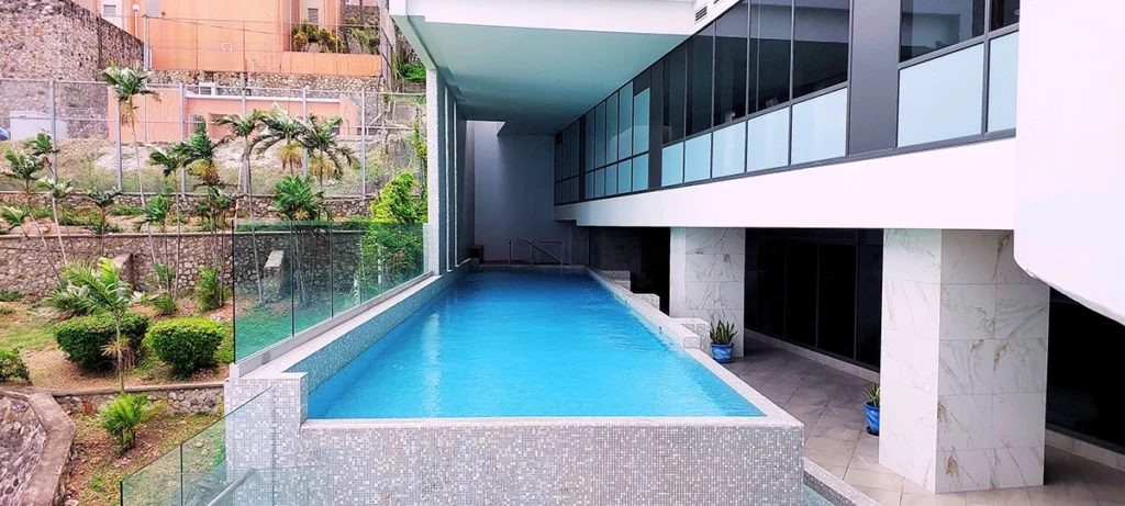 Pool next to concrete building and terraced gardens